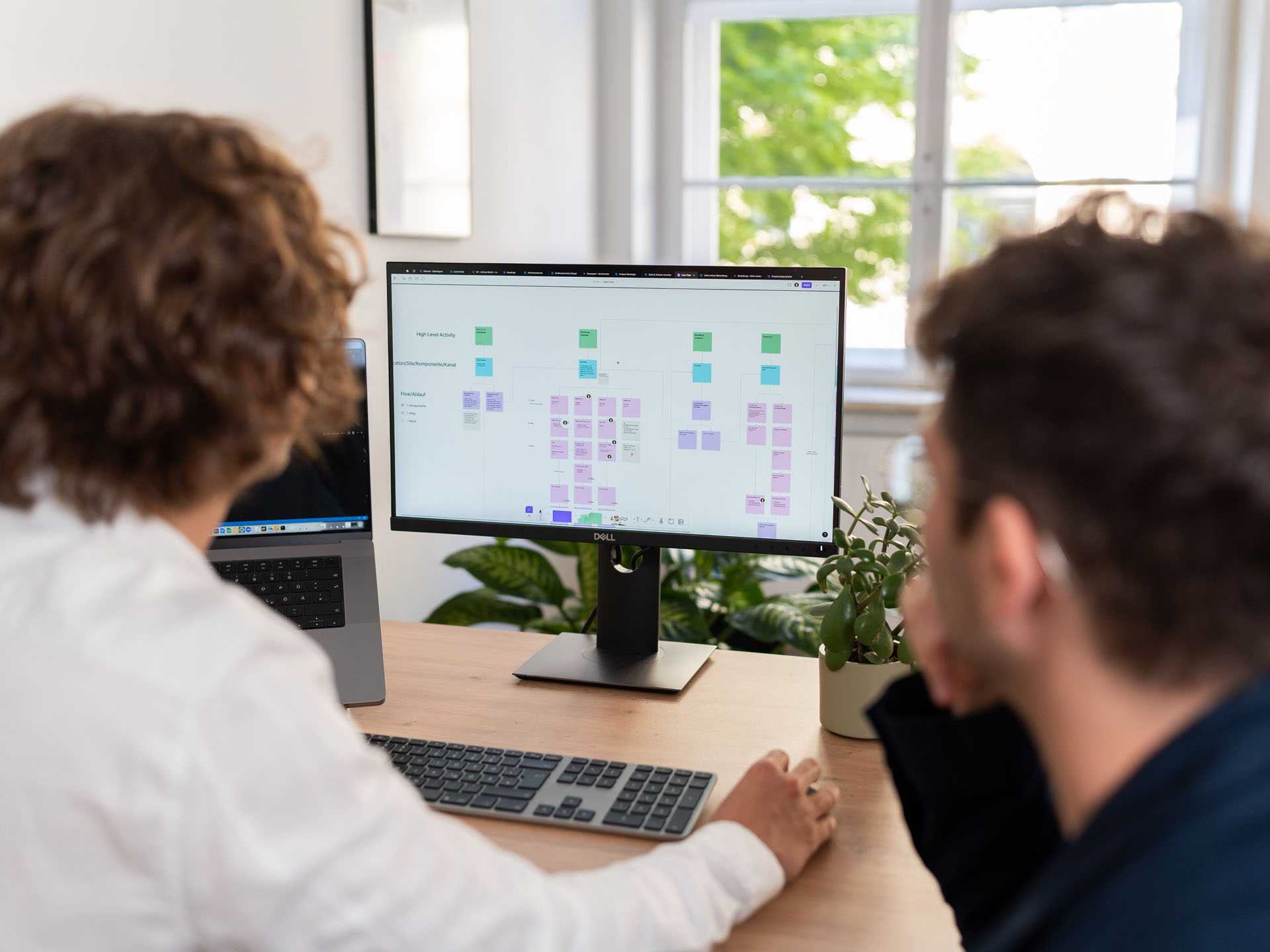 UX Designer Johnny shows Marketing Manager Kalle something on the PC.
