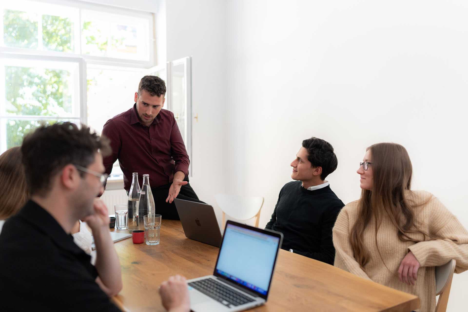 Several people are sitting together at a table in a meeting room.
