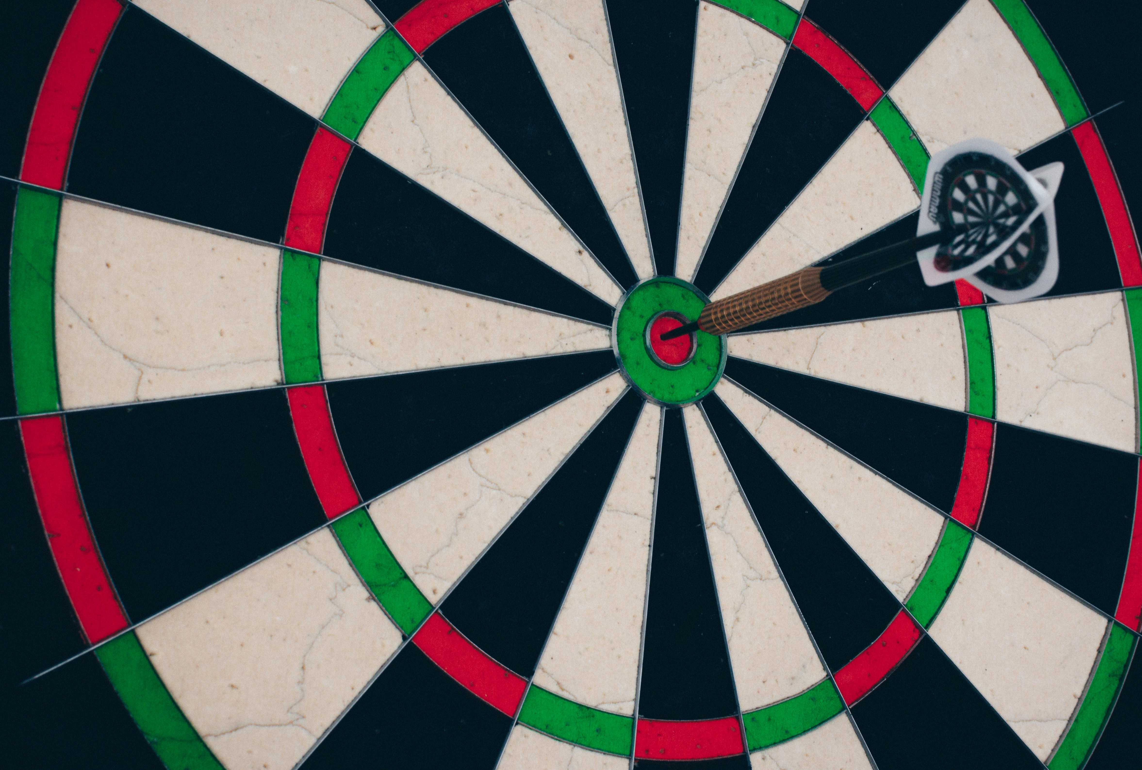 The image is intended to illustrate success through test-driven development. It shows a dart in the ‘bull's eye’ of a dartboard.