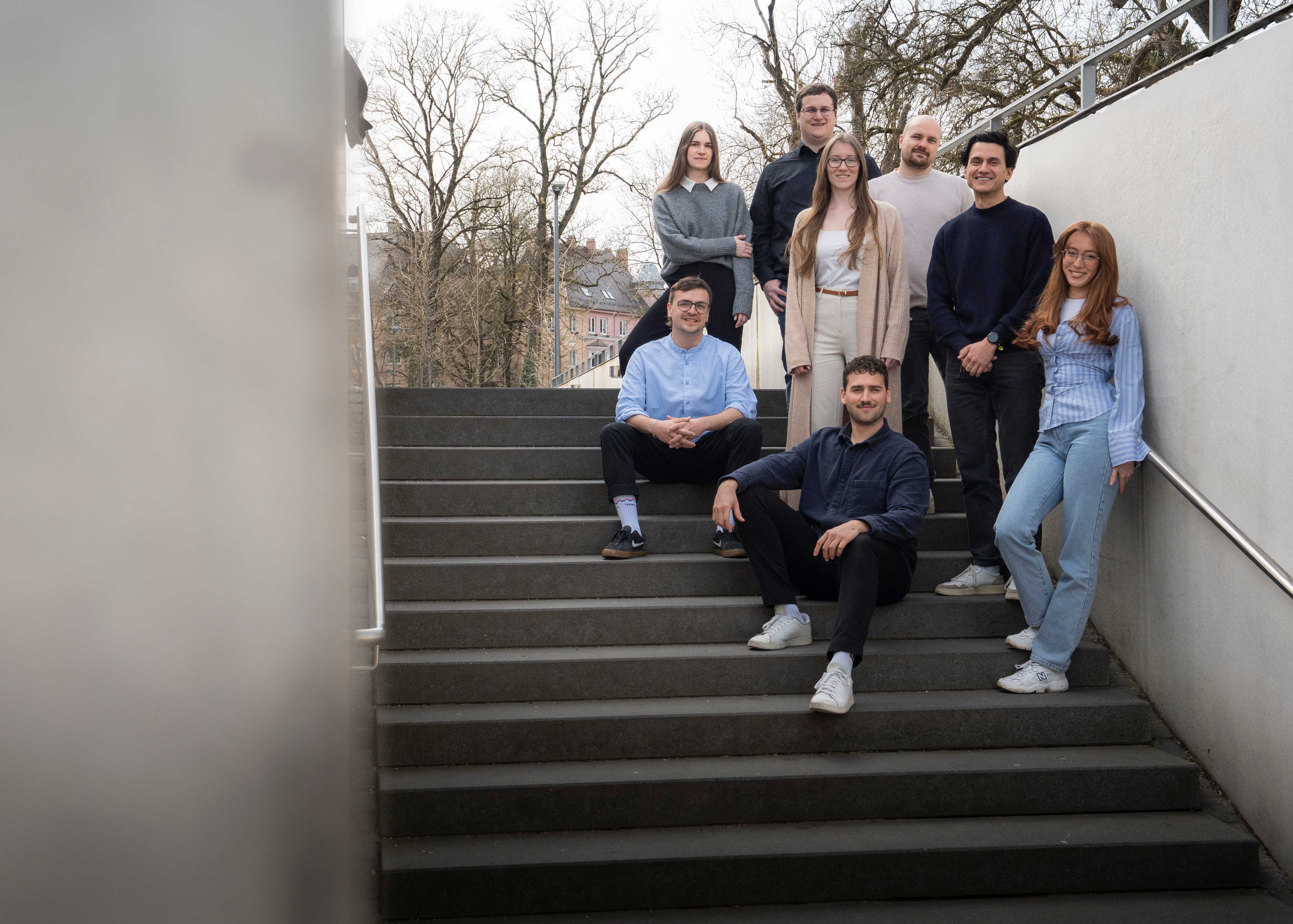 Das typedigital-Team sitzt auf einer Treppe in Augsburg.