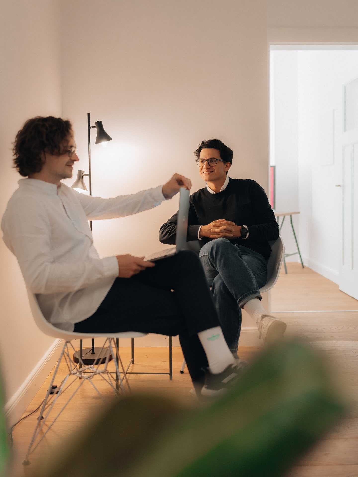 Two people are sitting on chairs and having a conversation.